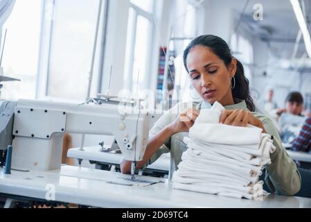 Schneiderin Frau näht Kleidung auf Nähmaschine in der Fabrik Stockfoto