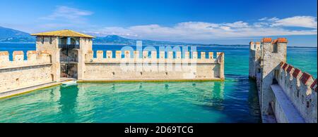 Sirmione, Italien, 11. September 2019: Kleiner befestigter Hafen mit türkisfarbenem Wasser, Scaligero Burg Castello Festung, Stadt am Gardasee, mittelalterliche Burg mit Steintürmen und Backsteinmauern, Lombardei Stockfoto