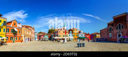 Burano, Italien, 14. September 2019: Zentraler Stadtplatz mit alten bunten bunten Gebäuden und italienischer Flagge, blauer Himmel im sonnigen Sommertag Hintergrund, Provinz Venedig, Region Venetien Stockfoto