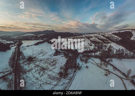 Untere Beskid, Karpaten Bergkette im Winter Luftbild, orange und rosa Himmel Stockfoto