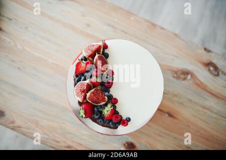 Blick von oben auf hausgemachten Kuchen mit Kirsche und Schokolade auf Es drinnen in der Küche Stockfoto