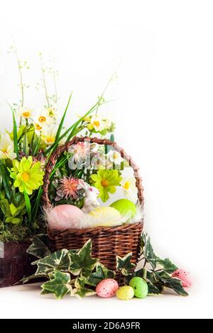 Frohe Ostern. Herzlichen Glückwunsch ostern Hintergrund. Bunte Ostereier und Blumen mit kleinen weißen Hasen im Korb. Stockfoto