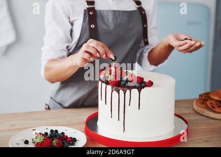 Nahaufnahme der Frau, die Kirschen auf die setzt Süßer Kuchen Stockfoto