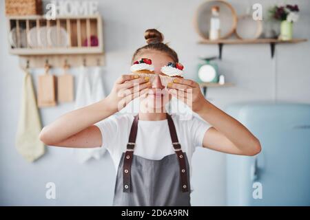 Frau steht drinnen in der Küche mit hausgemachtem Kuchen Stockfoto
