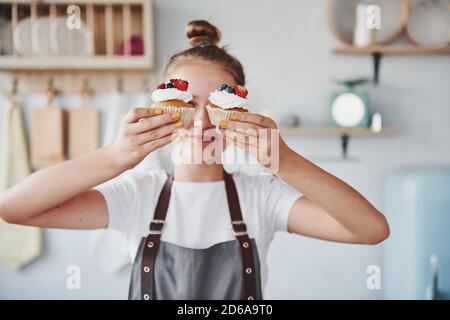 Frau steht drinnen in der Küche mit hausgemachtem Kuchen Stockfoto