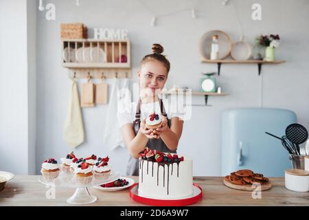 Frau steht drinnen in der Küche mit hausgemachtem Kuchen Stockfoto