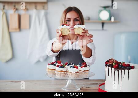 Frau steht drinnen in der Küche mit hausgemachtem Kuchen Stockfoto