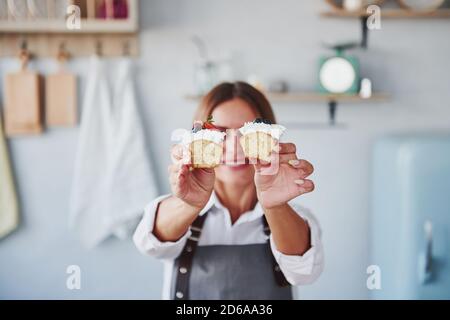 Frau steht drinnen in der Küche mit hausgemachtem Kuchen Stockfoto