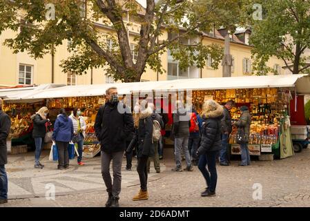 Stände von Straßenverkäubern in Meran, BZ, Italien im Herbst 15. Oktober 2020 Bild mit Touristen, die eine Gesichtsschutzmaske tragen. Stockfoto