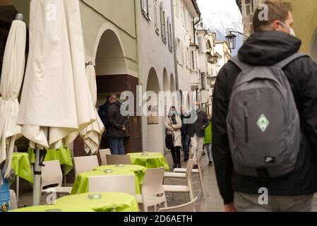 Berühmte Einkaufsstraße in Meran, Südtirol, Italien mit Menschen, die am 15. Oktober 2020 vorbei gehen und Gesichtsschutzmasken tragen. Stockfoto