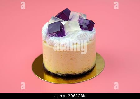 Kuchen mit Mango-Soufflé und Johannisbeergelee mit Schlagsahne gekrönt. Luftiger Biskuitkuchen mit Sahne. Kuchen mit Schlagsahne und Fruchtgelee darauf Stockfoto