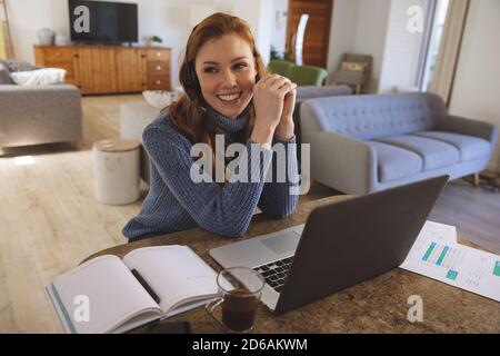 Frau, die ein Headset trägt, spricht zu Hause Stockfoto