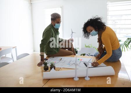 Frau trägt Gesichtsmaske Notizen im Büro Stockfoto