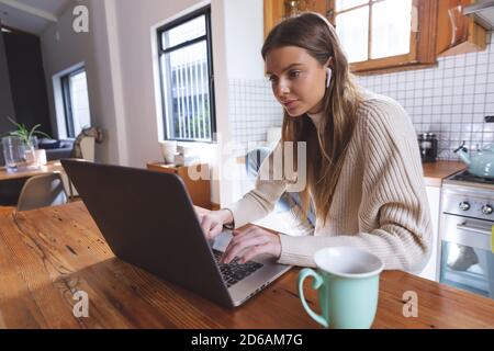 Frau mit Laptop in der Küche zu Hause. Stockfoto