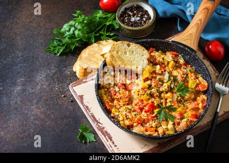 Türkische Küche. Menemen Rühreier in einer gusseisernen Pfanne auf einer steinernen Arbeitsplatte. Speicherplatz kopieren. Stockfoto