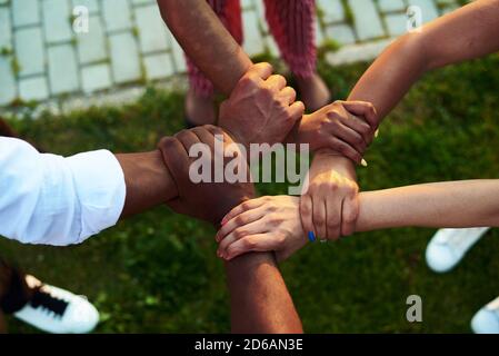 Schwarze Menschen mit Händen schlossen sich an. Gruppe von Personen, die Hände zusammenstapeln. Stockfoto