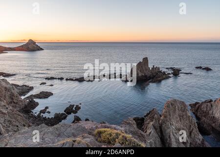 Schöner Sonnenuntergang an einer Küste voller großer Felsen Stockfoto