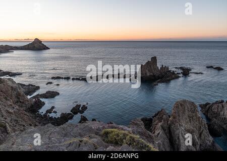 Schöner Sonnenuntergang an einer Küste voller großer Felsen Stockfoto