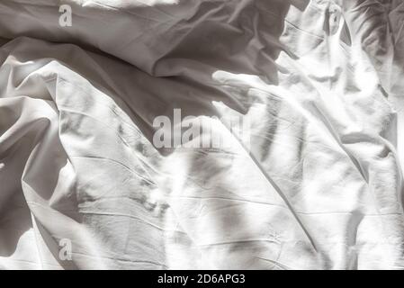 Ungemachtes Bett mit zerknittertem Textiltuch und Kissen Stockfoto