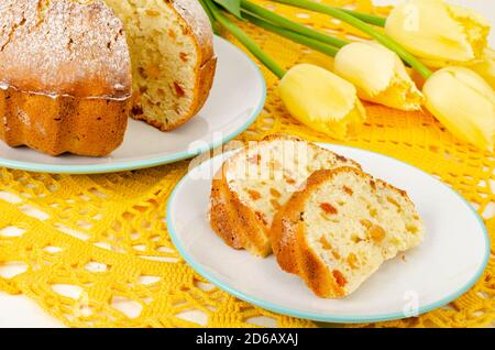 Hausgemachte Kuchen, gelbe Tulpen auf weißem Holztisch. Stockfoto