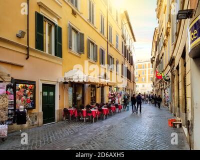 Ein kopfsteinpflaster Straße mit Bürgersteig Cafés und Souvenirläden im historischen Zentrum von Rom, Italien Stockfoto