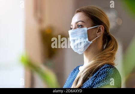 Frau trägt Schutzmaske im Büro für die Sicherheit Und Schutz während COVID-19 Stockfoto