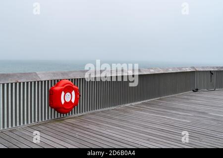 Holzstruktur des Pier von Hastings, East Sussex, England mit einem roten Rettungsring Lebensretter an einem Tag mit Meeresnebel im Sommer 2018 Stockfoto