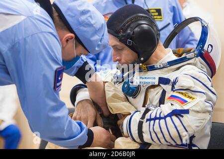 Baikonur, Kasachstan. Oktober 2020. Expedition 64 der russische Kosmonaut Sergej Ryschikow aus Roskosmos wird in seinen russischen Sokol-Anzug mitgeholfen, bevor er am 14. Oktober 2020 in Baikonur, Kasachstan, das russische Sojus MS-17-Raumschiff zum Start bestieg. Die Crew-Mitglieder Sergey Ryzhikov, Sergey KUD-Sverchkov von Roscosmos und NASA-Astronautin Kate Rubins starten eine sechsmonatige Mission zur Internationalen Raumstation. Quelle: Andrey Shelepin/NASA/Alamy Live News Stockfoto