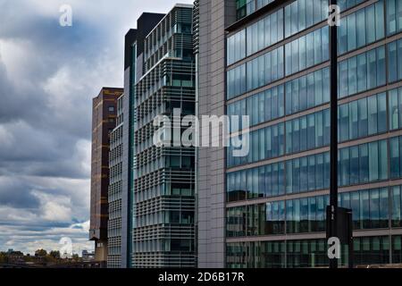 Großes, modernes Gebäude mit großen, blau reflektierenden Fenstern Bewölktes Wetter Stockfoto