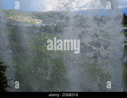 Blick Hinter Die Steinsdalsfossen-Wasserfälle Im Fluss Fosselva In Norwegen an EINEM sonnigen Sommertag mit EINEM klaren Blauer Himmel und EIN paar Wolken Stockfoto