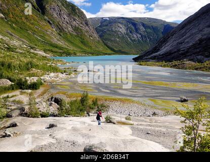 Frau Klettert Auf Die Felsen Am See Nigardsbrevatnet Auf Sie Weg Zum Gletscher Nigardsbreen Im Jostedalsbreen Nationalpark Auf Ein sonniger Sommertag mit Stockfoto