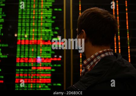 Passagiere an Bahnhöfen und Flughäfen halten sich an die Einschränkungen der COVID-19-Pandemie: Sie tragen Masken und beobachten soziale Distanzierungen. Stockfoto