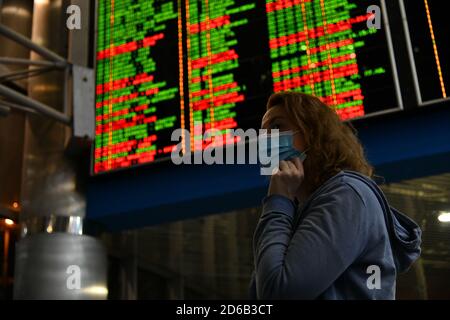 Passagiere an Bahnhöfen und Flughäfen halten sich an die Einschränkungen der COVID-19-Pandemie: Sie tragen Masken und beobachten soziale Distanzierungen. Stockfoto