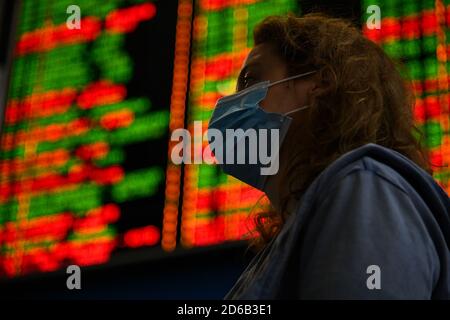 Passagiere an Bahnhöfen und Flughäfen halten sich an die Einschränkungen der COVID-19-Pandemie: Sie tragen Masken und beobachten soziale Distanzierungen. Stockfoto