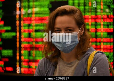 Passagiere an Bahnhöfen und Flughäfen halten sich an die Einschränkungen der COVID-19-Pandemie: Sie tragen Masken und beobachten soziale Distanzierungen. Stockfoto