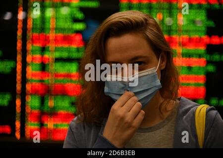 Passagiere an Bahnhöfen und Flughäfen halten sich an die Einschränkungen der COVID-19-Pandemie: Sie tragen Masken und beobachten soziale Distanzierungen. Stockfoto