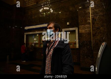 Passagiere an Bahnhöfen und Flughäfen halten sich an die Einschränkungen der COVID-19-Pandemie: Sie tragen Masken und beobachten soziale Distanzierungen. Stockfoto