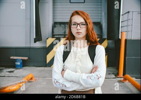 Porträt eines rothaarigen Mädchens in roter Brille. Stockfoto