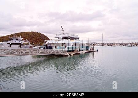 Yeppoon, Queensland, Australien - Dezember 2019: eine Freiheit, die schnelle Katzen Freizeitaktivitäten Schiff bereit zum Board Touristen, neben einem Polizei Boot in der Marina vor Anker Stockfoto