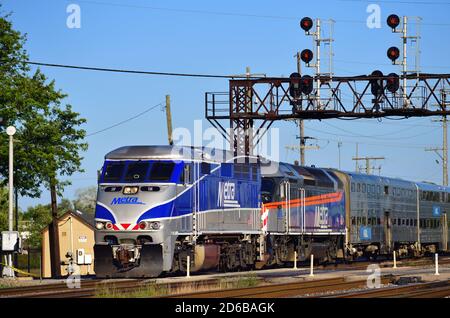 Franklin Park, Illinois, USA. Ein Metra-Pendlerzug, der unter einem Signalturm kurz vor der Ankunft am Franklin Park-Pendlerbahnhof vorbeifährt. Stockfoto