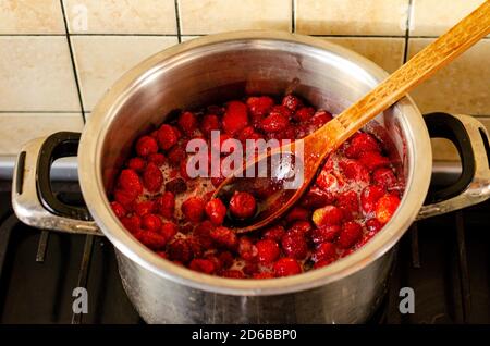 Erdbeeren werden mit Zucker in der Pfanne gekocht. Stockfoto