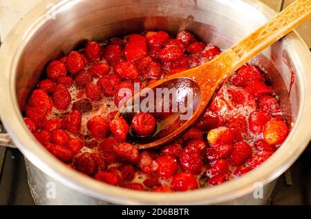 Erdbeeren werden mit Zucker in der Pfanne gekocht. Stockfoto
