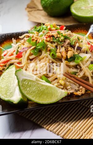 Authentische Küche Pad Thai mit Huhn Reis Nudeln Paprika Sojasprossen und Limette garnieren Stockfoto