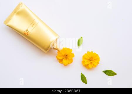 Naturkosmetik Sonnencreme spf50 Gesundheitspflege für Haut Gesicht mit Kosmos Blumen Lifestyle Frau Arrangement flach Lay Stil auf Hintergrund weiß Stockfoto