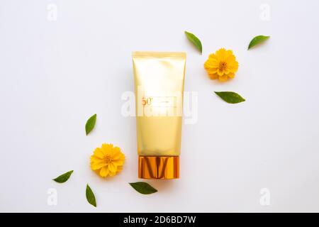 Naturkosmetik Sonnencreme spf50 Gesundheitspflege für Haut Gesicht mit Kosmos Blumen Lifestyle Frau Arrangement flach Lay Stil auf Hintergrund weiß Stockfoto