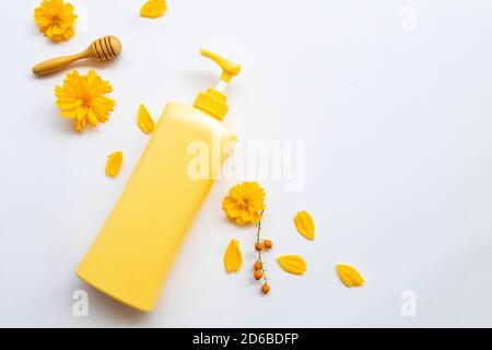 Sonnencreme Körperlotion Extrakt Honig Gesundheit Pflege für die Körperhaut Von Lifestyle Frau entspannen mit gelben Blumen Kosmos Anordnung flach Lay Style auf Weiß Stockfoto