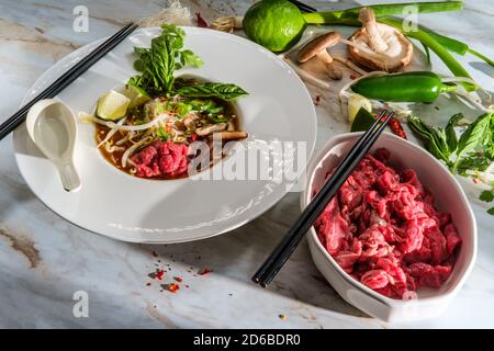 Traditionelle vietnamesische Pho bo-Rind-Nudelsuppe mit Nudeln Basilikum Koriander-Pilze und Bohnensprossen serviert Stockfoto