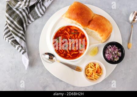 Spicy Misal Pav oder Sal Pav ist ein traditioneller Snack oder Chaat-Essen aus Maharashtra, Indien. Serviert mit gehackten Zwiebeln, Zitronenkeilchen und farsan. Stockfoto