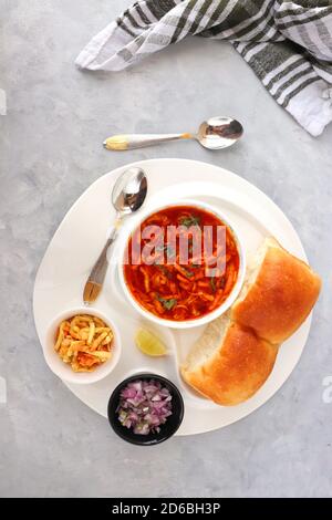 Spicy Misal Pav oder Sal Pav ist ein traditioneller Snack oder Chaat-Essen aus Maharashtra, Indien. Serviert mit gehackten Zwiebeln, Zitronenkeilchen und farsan. Stockfoto