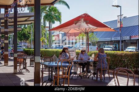 Mackay, Queensland, Australien - 2020. Juni: Drei Freundinnen bestellen von der Speisekarte in einem Straßencafé im Freien während der Pandemie, wenn soziale Scham Stockfoto